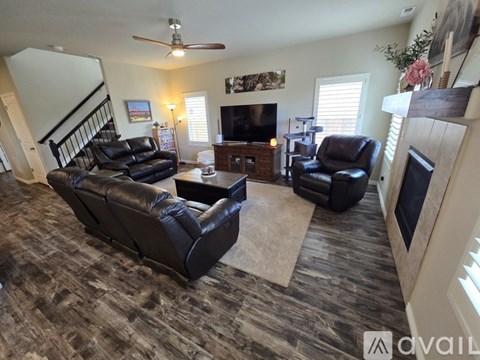 A living room with a black leather couch and a television.