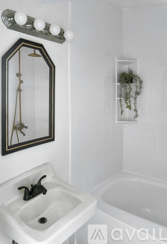 A bathroom with a white sink and a mirror.