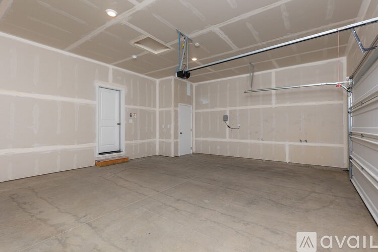 A spacious room with a door and a window, and a wall with pipes.