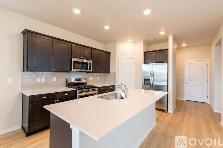 A kitchen with a white counter top and black cabinets.