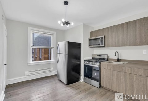 A kitchen with a black refrigerator, stove, and microwave.