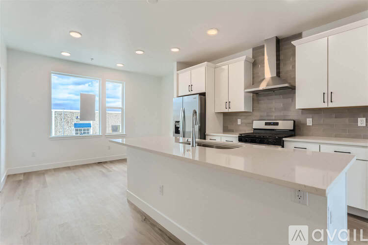 A kitchen with white cabinets and a large island.