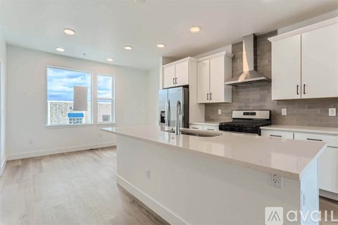A kitchen with white cabinets and a large island.