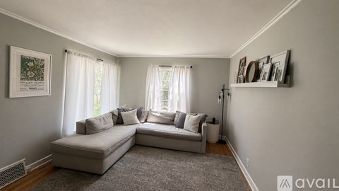 A living room with a grey sofa and a grey rug.