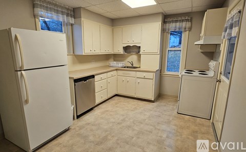 A kitchen with white appliances and cabinets.