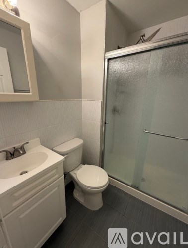 A bathroom with a toilet, sink, and shower.