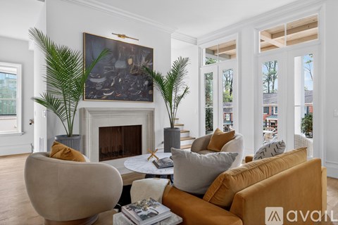 A living room with a fireplace and a painting above it.