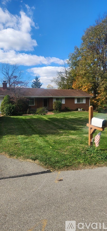 A house with a brown roof and a mailbox on the front lawn.
