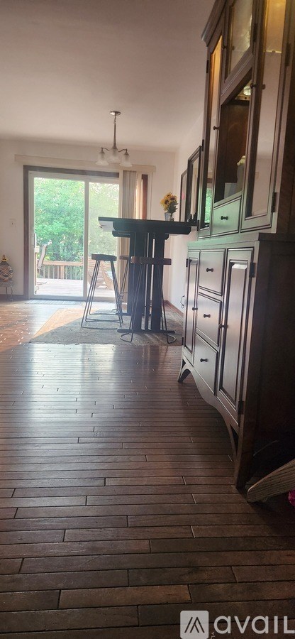 A kitchen with a table and chairs in front of a sliding glass door.