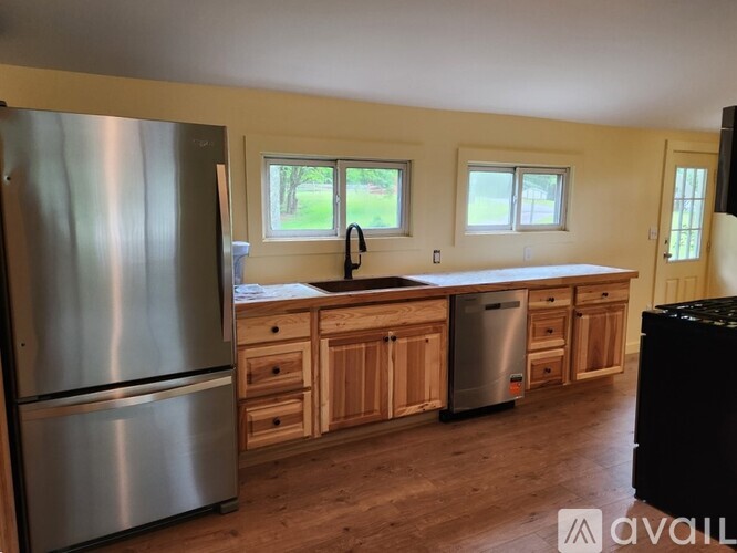A kitchen with wooden cabinets and a stainless steel refrigerator.