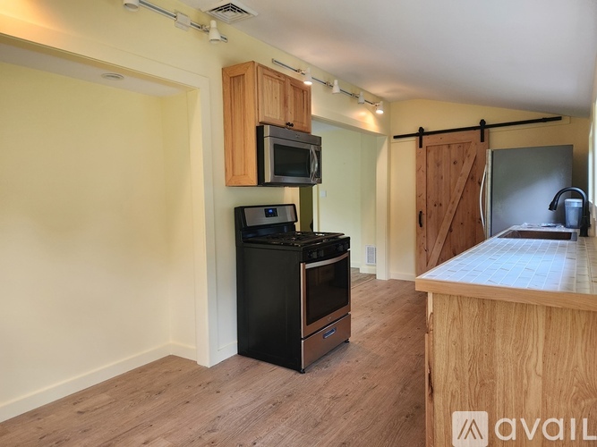 A kitchen area with a black oven and microwave.