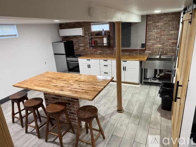 A kitchen with a wooden table and bar stools.