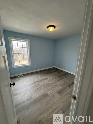 A room with light blue walls and a window.
