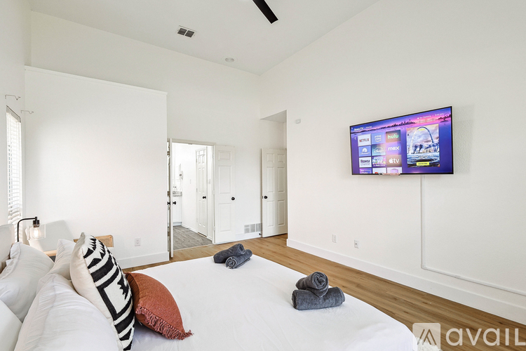 A bedroom with a large bed and a flat screen TV mounted on the wall.
