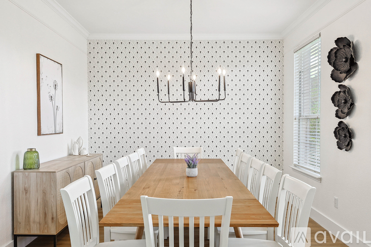 A dining room with a wooden table and white chairs.
