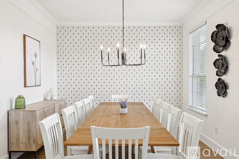 A dining room with a wooden table and white chairs.