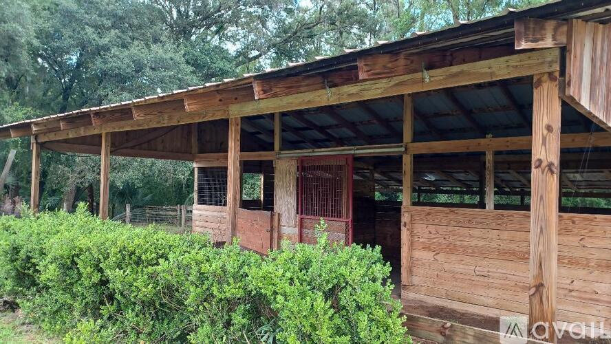 A wooden building with a metal roof and a red door.