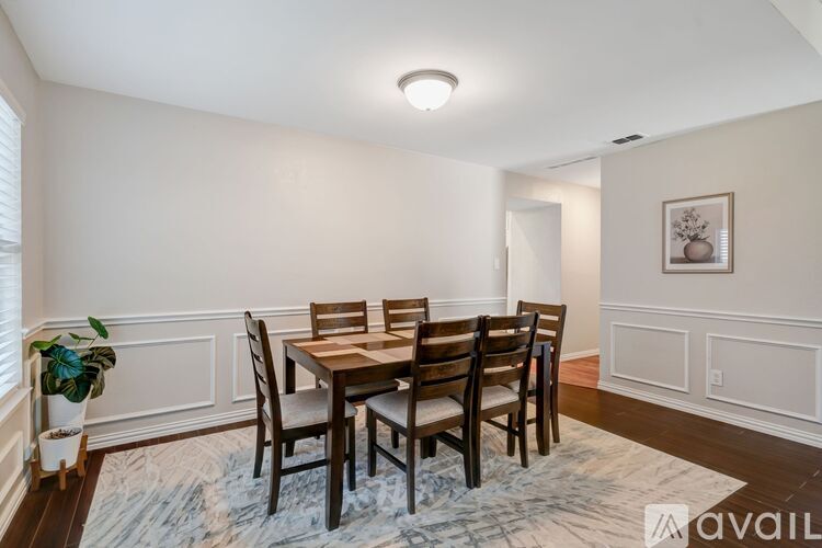 A dining room with a table and chairs.