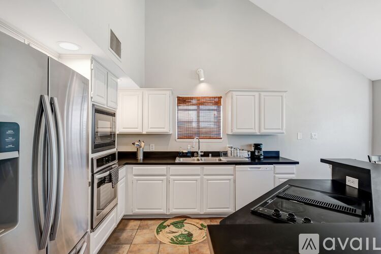 A kitchen with a black counter top and white cabinets.