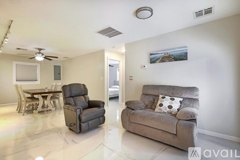 A living room with a grey couch and a black chair.