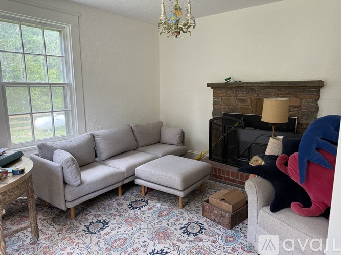 A living room with a grey couch, a small table, and a fireplace.