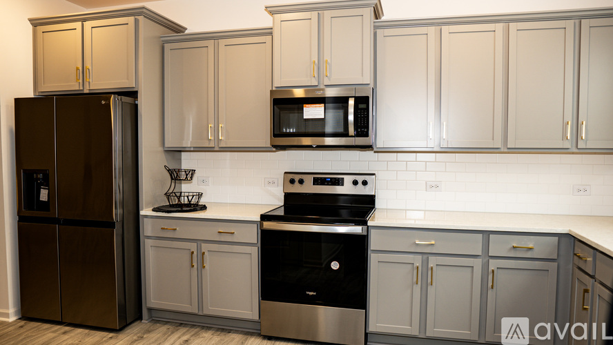 A kitchen with a black refrigerator, stainless steel dishwasher, and stove.