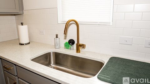 A kitchen sink with a green mat on the counter.