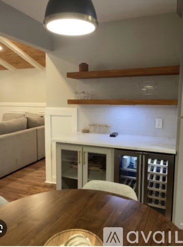 A kitchen with a wooden table and a white fridge.