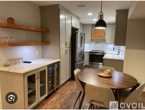 A kitchen with a table and chairs in the middle.