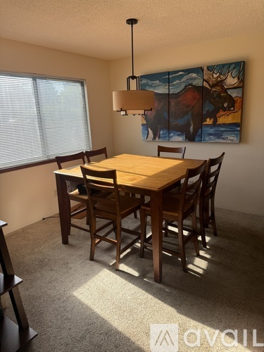 A dining room with a wooden table and chairs.