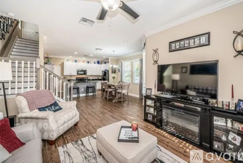 A living room with a white couch and a television.