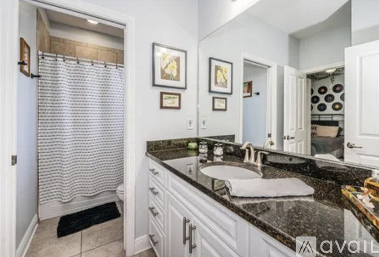 A bathroom with a sink, mirror, and shower.
