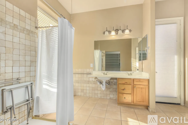 A bathroom with a white shower curtain and a wooden vanity.