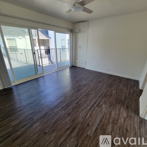 A room with wooden flooring and a ceiling fan.