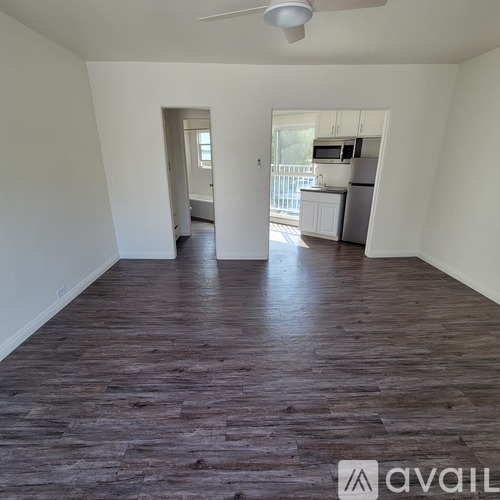 A room with wooden flooring and a ceiling fan.