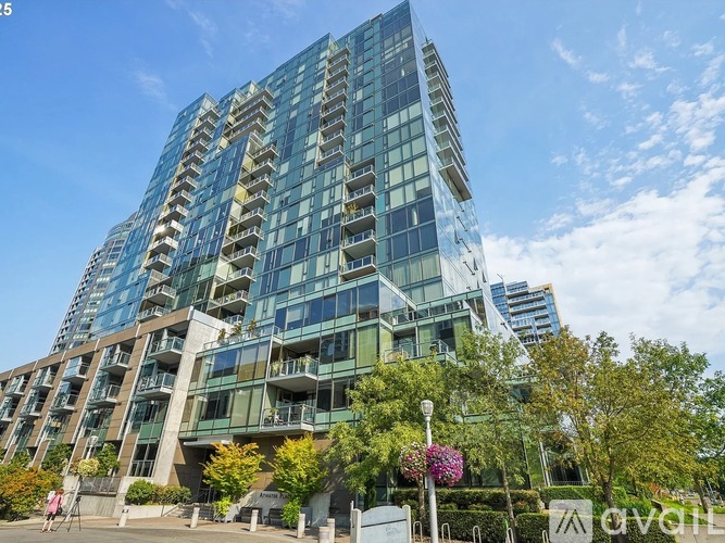 A modern glass building with trees in front.