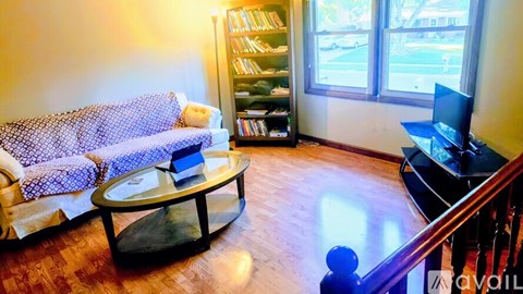 A living room with a couch, a coffee table, and a television.