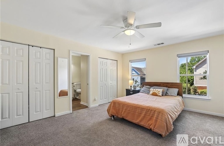 A bedroom with a large bed and a ceiling fan.