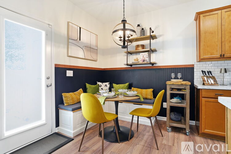 A kitchen with a dining table and chairs.