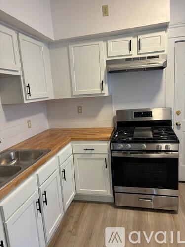A kitchen with white cabinets and a stainless steel oven.