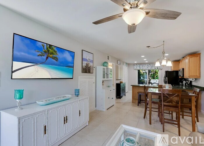 A living room with a television displaying a beach scene.
