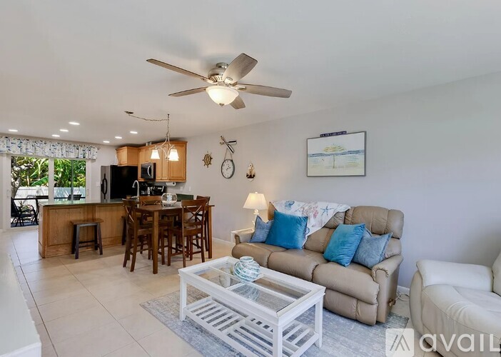 A living room with a white ceiling fan and a white coffee table.