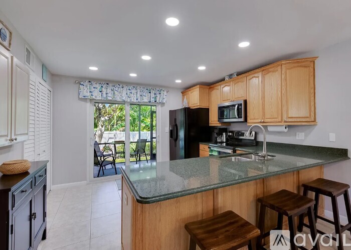 A kitchen with wooden cabinets and a granite countertop.