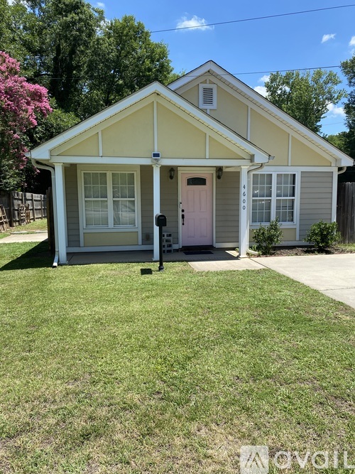 A small house with a pink door and a white window.