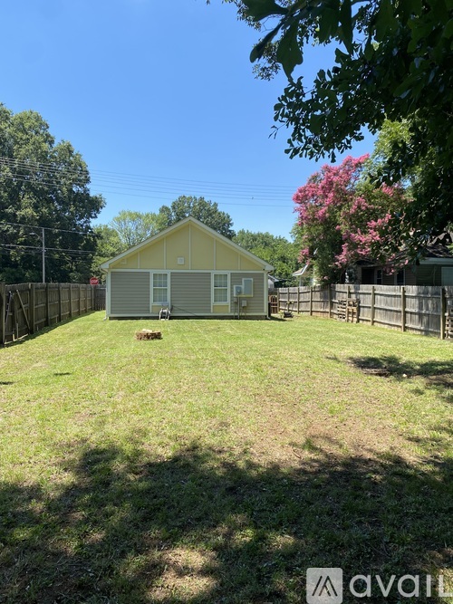 A house with a fence and trees in the background.