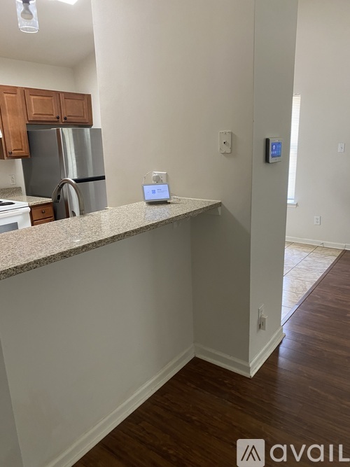 A kitchen with a stainless steel refrigerator and wooden cabinets.