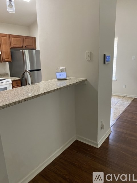 A kitchen with a stainless steel refrigerator and wooden cabinets.