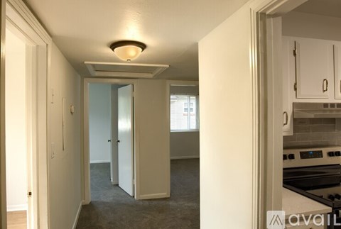 A kitchen area with a stove top oven and a carpeted floor.