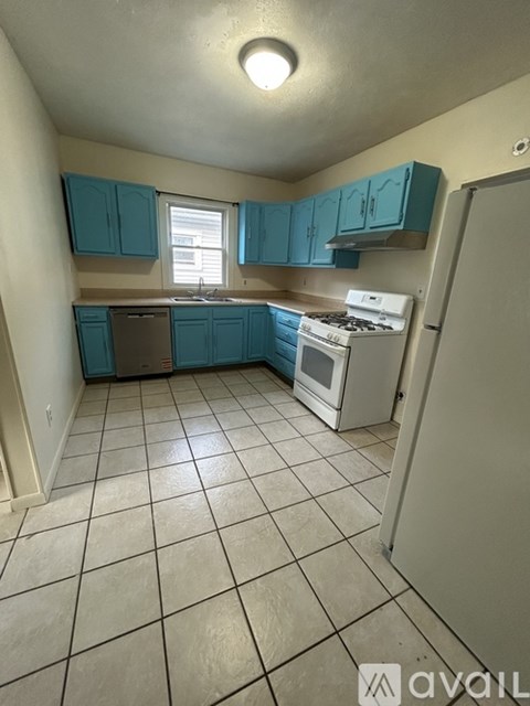 A kitchen with blue cabinets and white appliances.