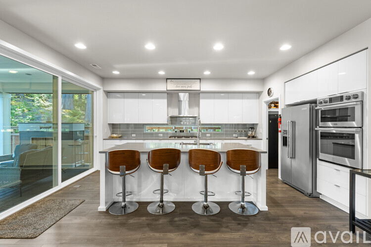 A modern kitchen with white cabinets and a bar area.